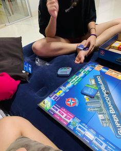 a person sitting on the floor with a board game in front of them and other items