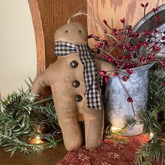 a christmas decoration with a gingerbread man next to a potted plant and tin can