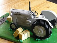 a cake made to look like a tractor and some blocks of butter on the ground