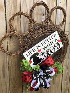 a life is better with a dog door hanger on a wooden fence next to a wreath