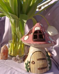 a small mushroom shaped house next to some flowers