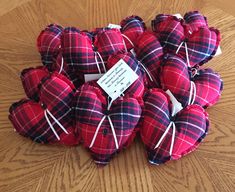 a pile of red and black plaid hearts on a wooden table with a price tag