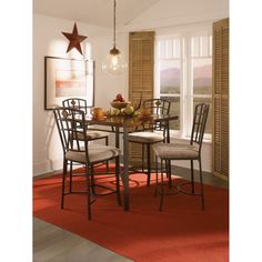 a dining room table with four chairs and a star hanging from the ceiling above it