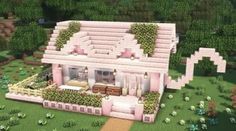 a house made out of pink blocks in the middle of some trees and bushes with plants growing on it