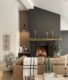 a living room filled with furniture and a fire place covered in candles next to a fireplace