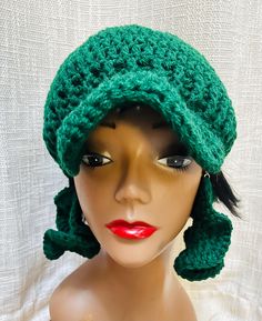 a mannequin head wearing a green crocheted hat on top of a white background