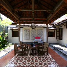 a covered patio with chairs and tables in it