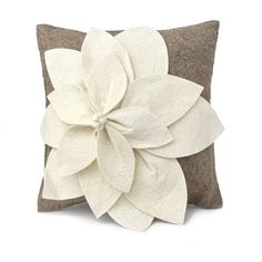 a pillow with a white flower on the front and brown back, sitting on a white background