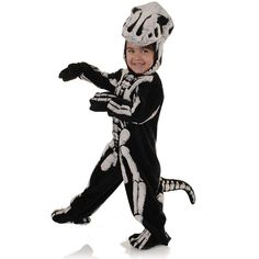 a little boy in a skeleton costume is running with his arms out and feet apart