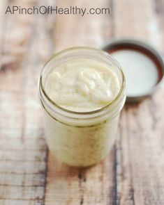 a jar filled with cream sitting on top of a wooden table