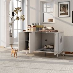 a cat is standing in the middle of a room next to a table with two cats on it