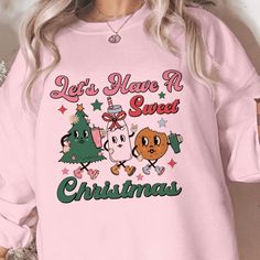 Indulge in the sweetness of the holidays with our 'Festive Delight 'Sweet Christmas' Sweatshirt'! With an adorable design featuring festive characters, it's perfect for holiday gatherings or just adding a touch of cheer to your winter wardrobe. Proudly handcrafted by our small business, this sweatshirt comes in an assortment of colors and sizes to fit your holiday celebration. Visit our website to find the perfect color and size for your festive season style! Please choose between long sleeve t Cute Winter T-shirt For Loungewear, Cute Holiday Crew Neck Sweatshirt, Cute Crew Neck Sweatshirt For Holiday, Sweet Crew Neck Top For Fall, Sweet Fall Crew Neck Top, Cute Holiday Graphic Print Tops, Cute Christmas Graphic Print Sweatshirt, Cute Christmas Sweatshirt With Graphic Print, Cute Christmas Sweatshirt With Letter Print