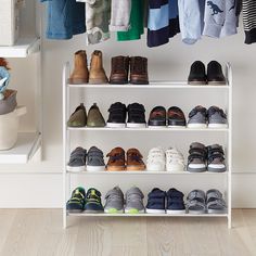 a white shelf filled with lots of shoes next to a closet full of baby's clothes