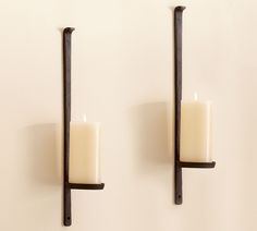 two candles are on the wall next to each other