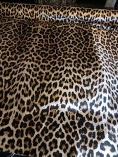 an animal print sheet is laying on top of a bed