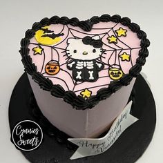 a hello kitty birthday cake on a black plate