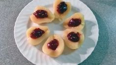 small pastries on a plate with jam in the middle