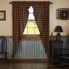 a room with a chair, table and window in front of the curtained windows