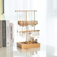 a jewelry organizer on a table in front of a laptop computer and bookshelf