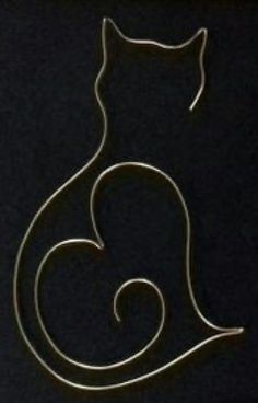 a metal cat sitting on top of a black surface with its tail curled in the shape of a spiral