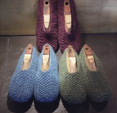 four pairs of slippers are lined up in different colors and sizes, one is made out of yarn