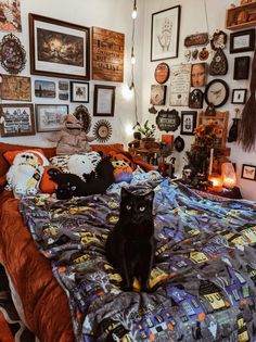 a black cat sitting on top of a bed in a room filled with pictures and decorations