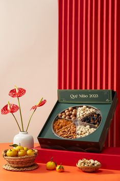 an assortment of nuts in a gift box on a table next to other food items