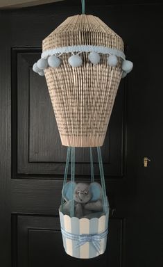 a stuffed animal in a basket hanging from a door