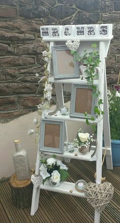 an old ladder is decorated with flowers and pictures