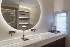 a bathroom with a round mirror above the sink