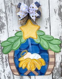 a wooden plaque with a nativity scene painted on it's side and decorations around the edges