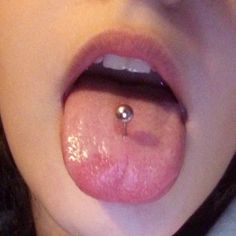 a close up of a person with a piercing on their tongue