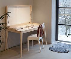 a white desk and chair in front of a window