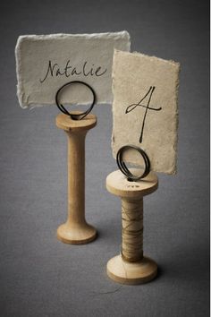 two rings are sitting on top of a wooden stand next to a sign that says natatie