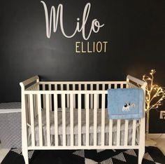 a white crib in front of a black and white wall