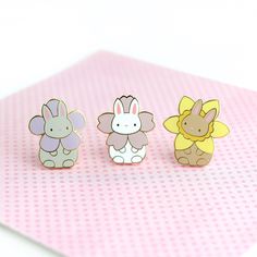 three little animal pins sitting on top of a pink table