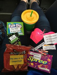 a person sitting on a couch with snacks and drinks in front of their feet,