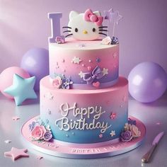 a hello kitty birthday cake with balloons and confetti