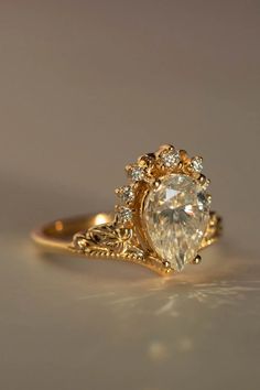 a gold ring with a pear shaped diamond