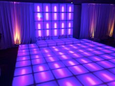 the dance floor is lit up with purple lights