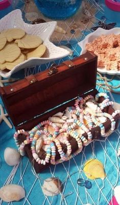 an open trunk sitting on top of a table filled with cookies and other food items