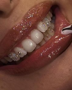 a close up of a person with glitter on their teeth