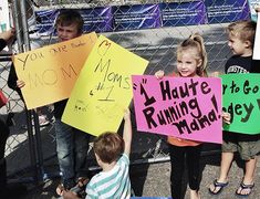 several children holding up signs in front of a fence