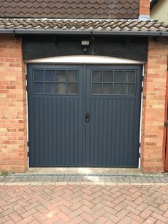 a brick building with two garage doors on each side and one door open to let in light