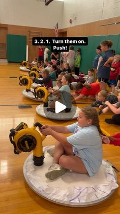 a group of people sitting on top of a wooden floor next to yellow fire hydrants