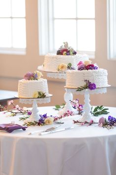 three tiered wedding cakes sitting on top of a table