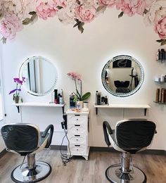 a salon with two chairs and flowers hanging from the ceiling