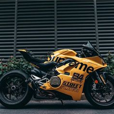 a yellow motorcycle parked in front of a building