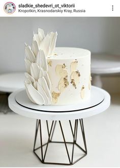 a white cake sitting on top of a metal stand