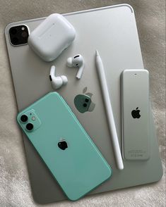 an iphone, headphones, and other electronics are sitting on a table next to each other